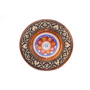 traditional wooden plate with red handcrafted design in the middle